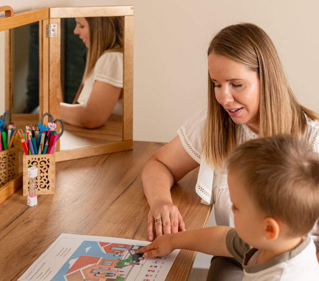 Terapeutka pracuje z dzieckiem przy stoliku